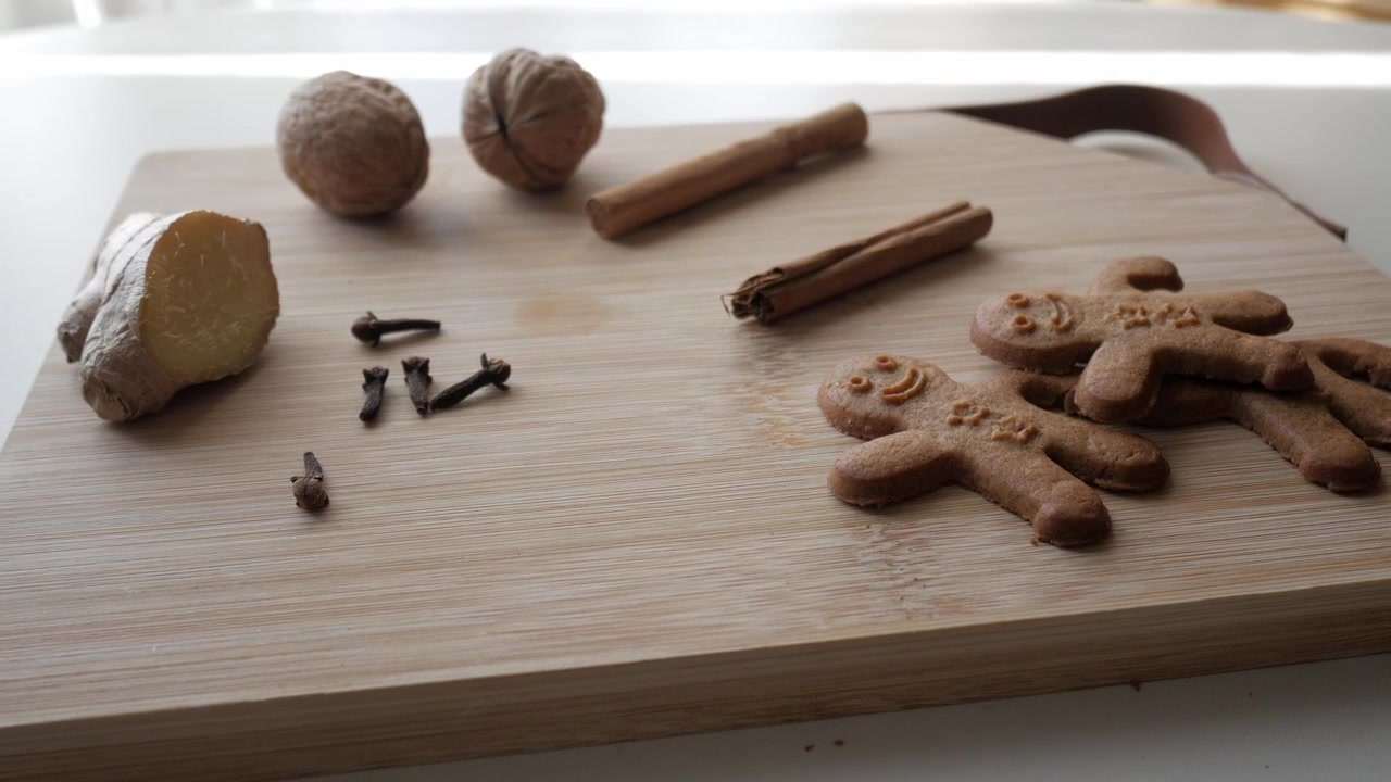 Ripresa in dolly out di omini di pan di zenzero e i suoi ingredienti su tagliere di legno