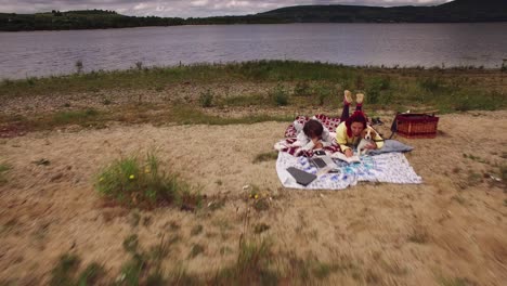 4k aerial family having picnic next to the lake