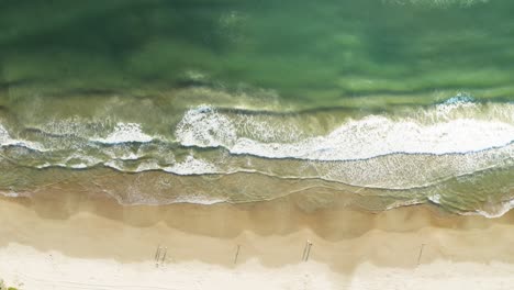 beautiful drone cinematic top view of a brazilian beach with white sand and emerald clear water at sunrise