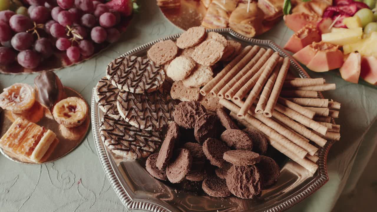 variety of sweet biscuits and rolled wafers on elegant serving platter