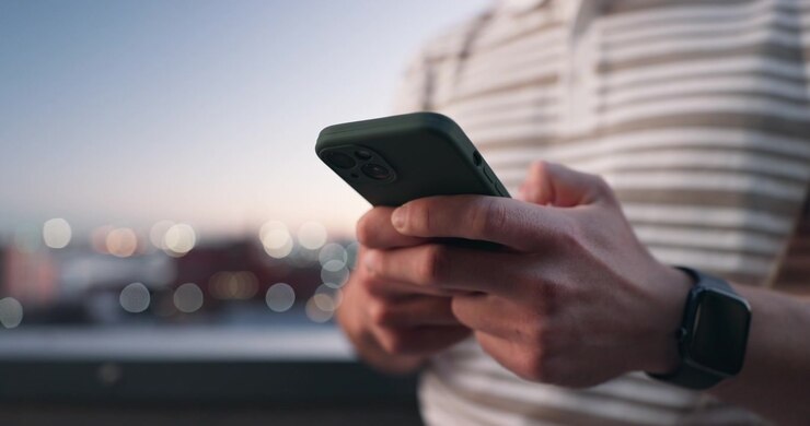 Persona che usa uno smartphone all'aperto al crepuscolo