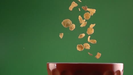 copos de maíz cayendo sobre un plato sobre un fondo cromático