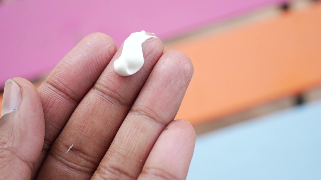 Close-up of White Skincare Cream on Human Finger