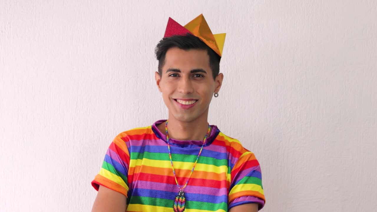 Young beardless homosexual man smiling at camera in lgbtq pride