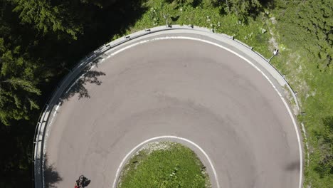 Von-Oben-Nach-Unten-Eines-Radfahrers-Auf-Einer-Haarnadelkurve-Straße-Minimalistisch,-Italien