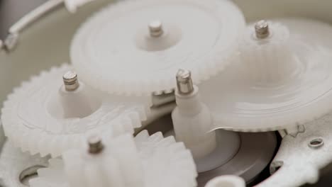 five plastic gears rotate in mutual mesh inside a small reduction gear