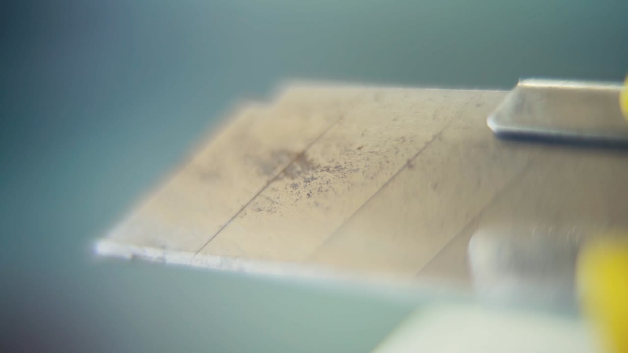 video macro de un cuchillo de utilidad, sacar la navaja de acero, cámara lenta 120 fps, disparo estático