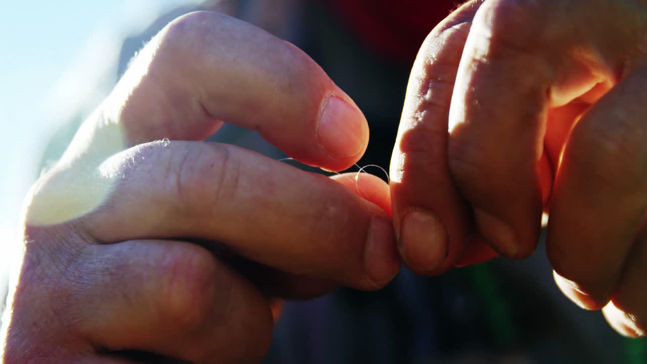 pescador con mosca preparando la línea de pesca para la pesca
