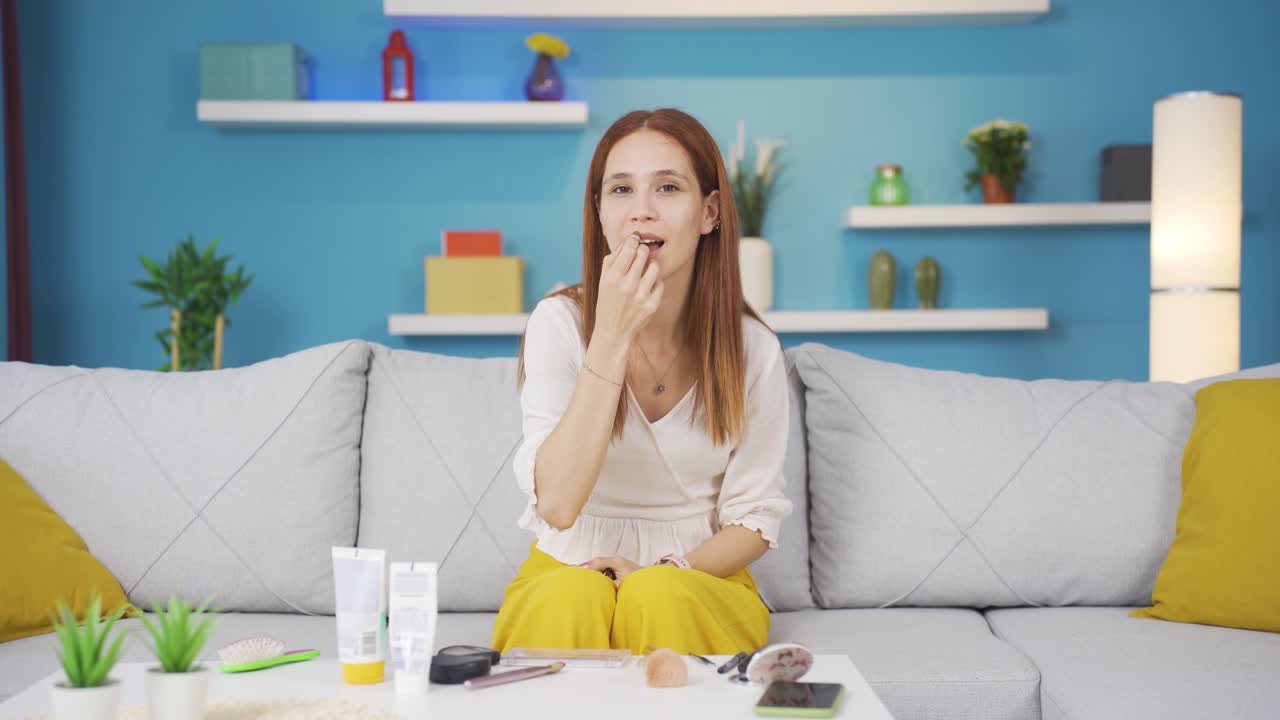 립스틱을 쓰는 젊은 여성.