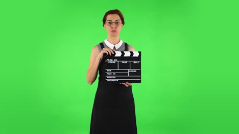 mujer con clapperboard en la pantalla verde