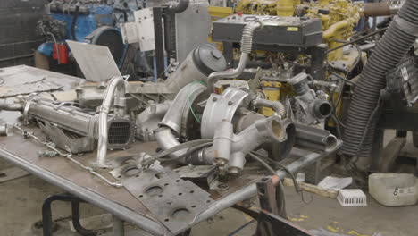 spare engine parts components rest on a workbench in a diesel repair shop slider shot with parallax