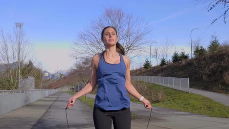 athletic young woman skipping along path outdoors realtime