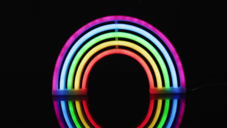 animation of colorful neon lights forming rainbow on black background