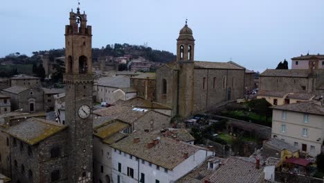 Vista-Aérea-De-La-Torre-Del-Reloj-En-El-Casco-Antiguo-De-Montalcino,-Italia,-Estableciendo