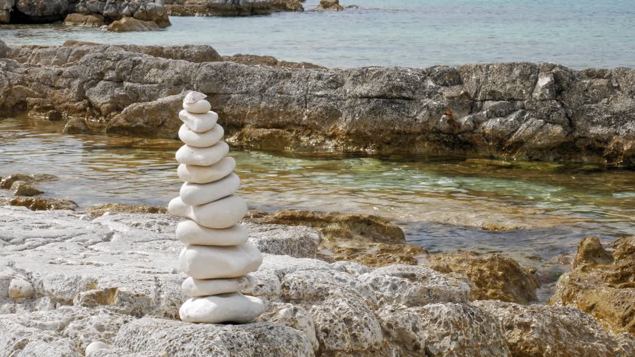 pilas de roca balanceada de piedra en la playa de paralia emplisi en grecia - tiro estático