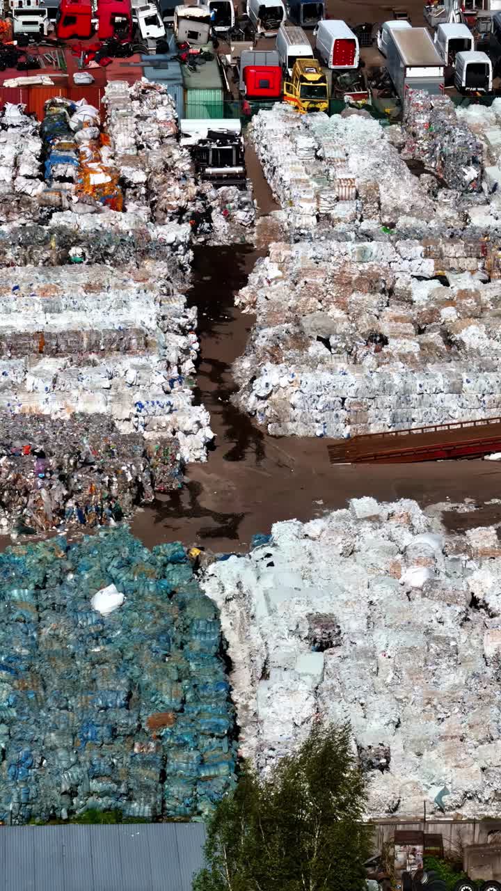 Stacks of Compressed Waste Await Processing at a Recycling Facility - Aerial Drone Shot
