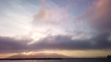 Gimbal-panning-shot-from-the-sky-to-fog-rolling-over-the-Golden-Gate-Bridge-at-magic-hour-in-San-Francisco,-California