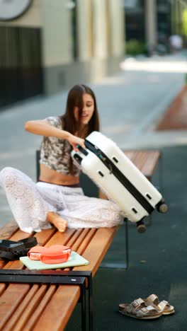 woman preparing for travel on a park bench