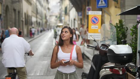 young woman using a mobile phone in florence, italy