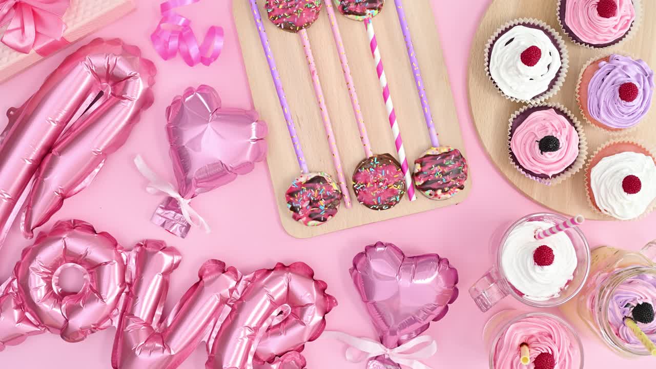 la mano de la mujer tomando una taza de pastel del día de san valentín decorada con tema rosa pastel.