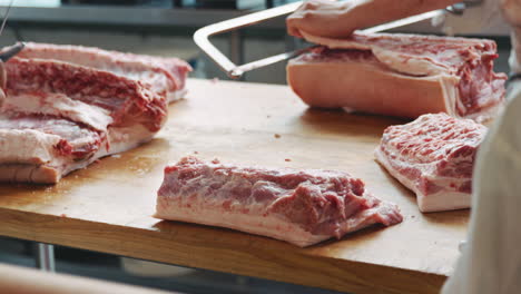 tres carniceros jóvenes preparando carne en una carnicería