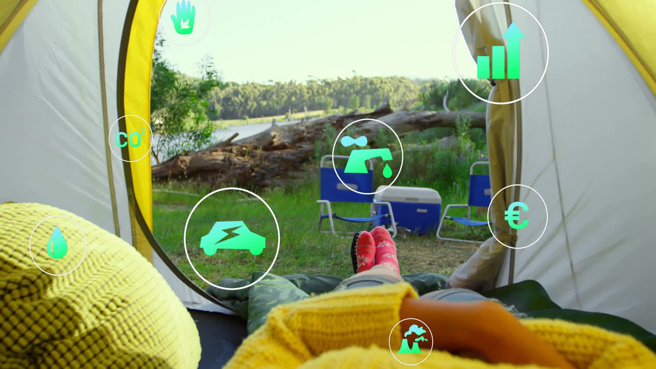 Animation of camping scene with digital icons showing environmental and energy concepts