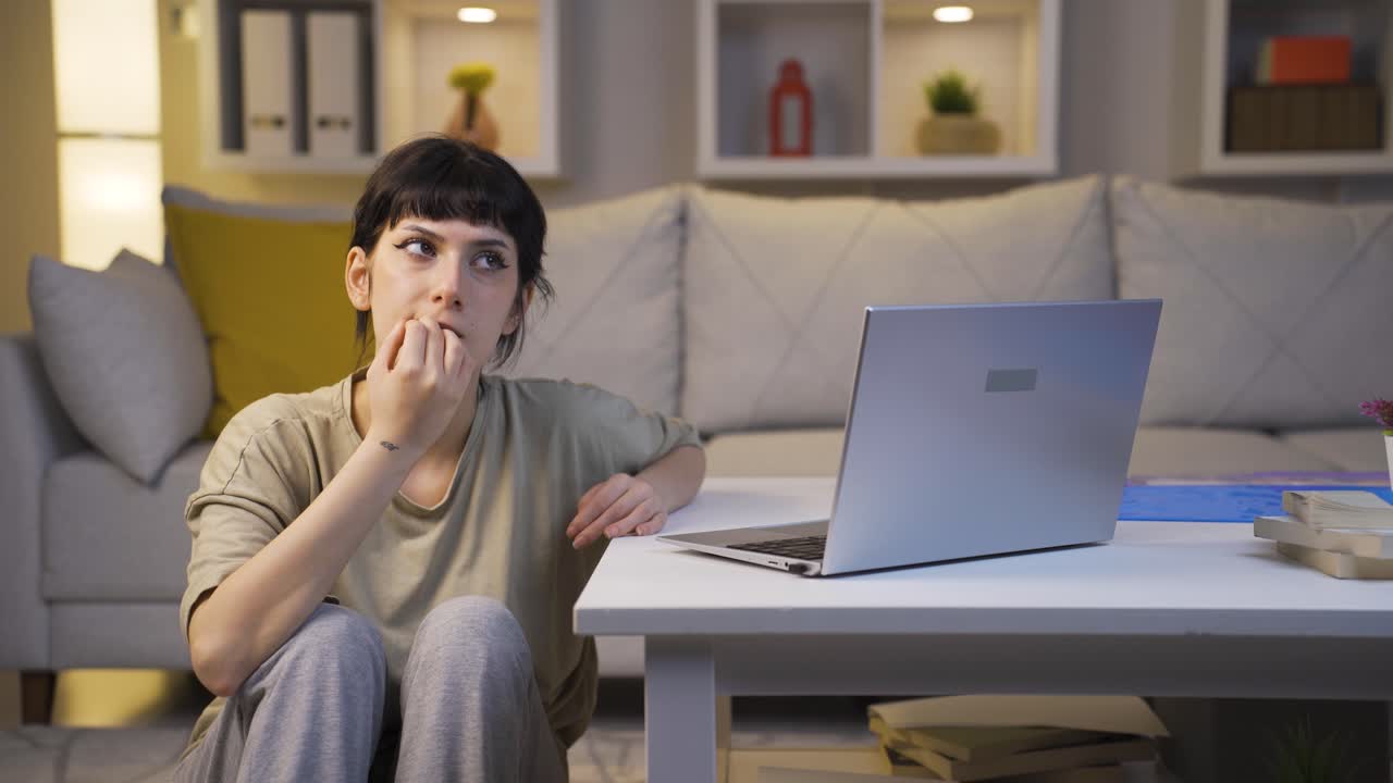 молодая женщина кусает ногти из-за стресса дома по ночам.