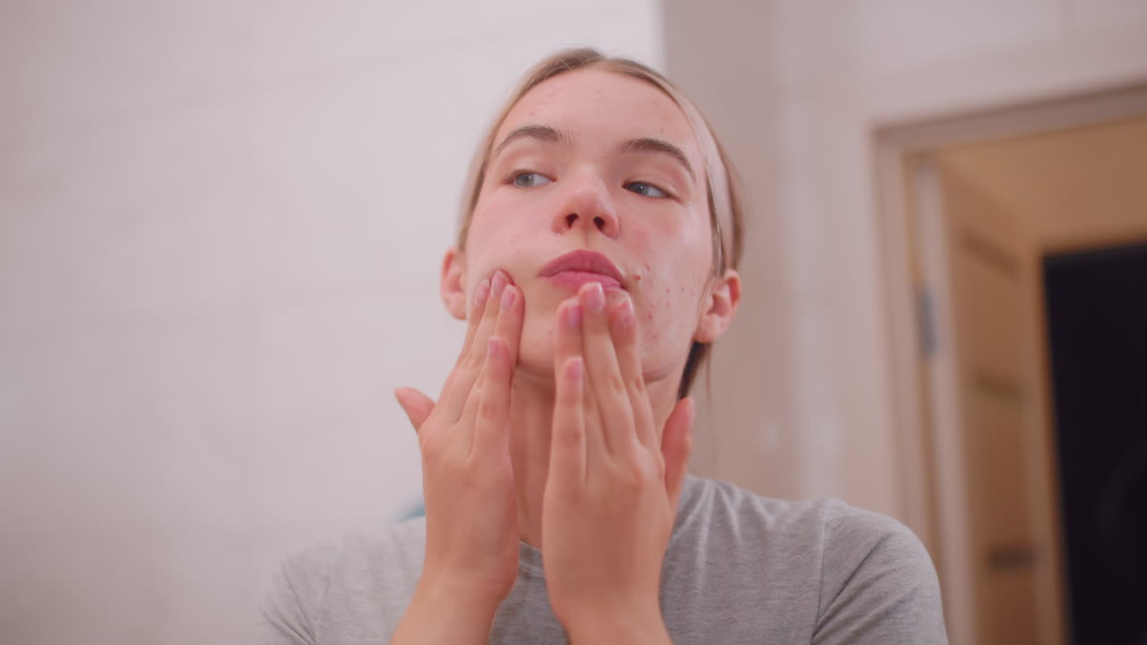 Primo piano di una donna che applica delicatamente della crema sul viso, concentrandosi su cura della pelle, bellezza, cura di sé, idratazione e routine naturale per promuovere benessere e incarnato liscio