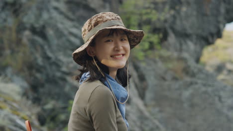 portrait of cheerful asian female tourist in nature