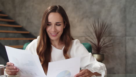 happy business woman reading documents at modern office.