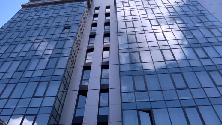El cielo reflejado en un edificio con paredes de cristal