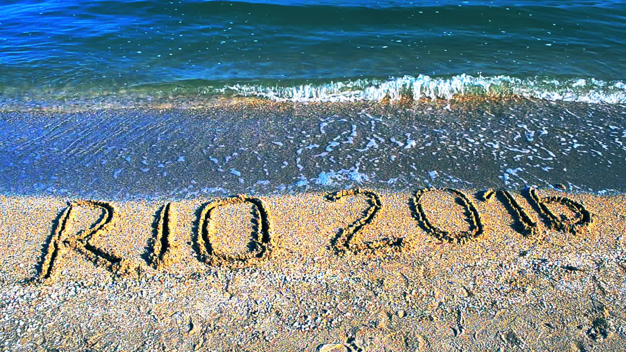 Rio 2016, en inskription i sandet på stranden. Symbol for olympiske lege i sandet på stranden.