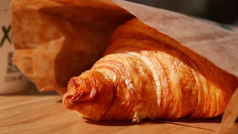 freshly baked croissant in paper bag