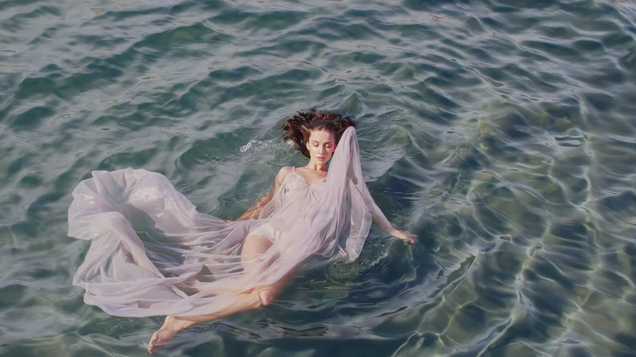 물 위에 떠다니는 드레스를 입은 여자