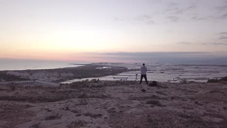 photographer capturing sunrise panorama over coastline and farmland