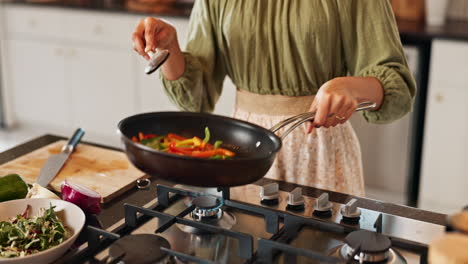 mujer cocinando pimientos en una estufa