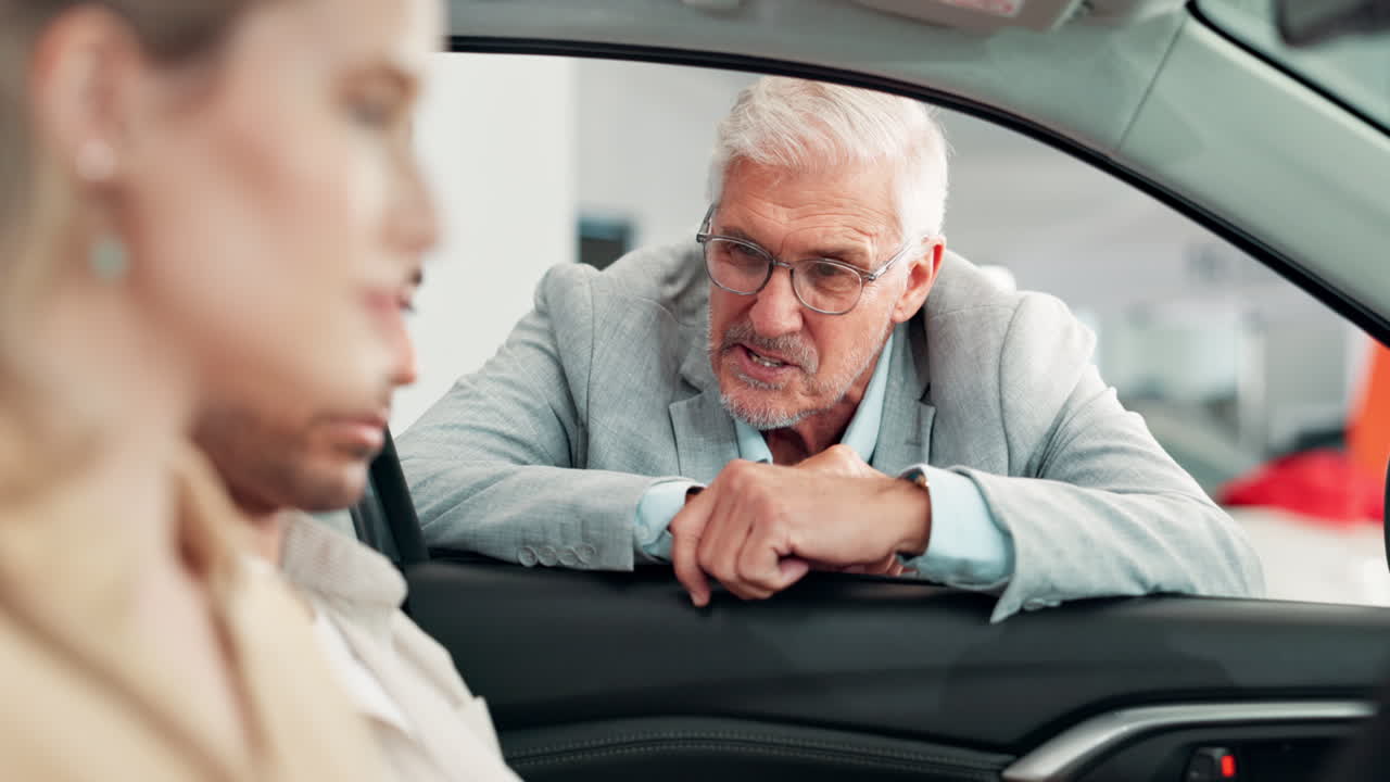 Car salesman talking to a customer in a dealership