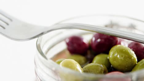 un frasco lleno de aceitunas en vinagre