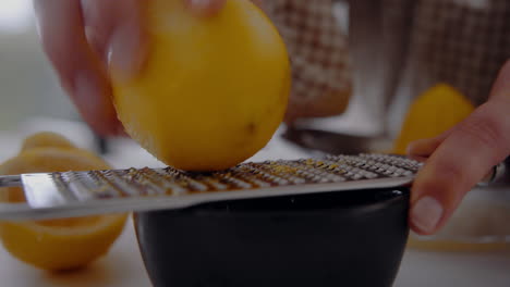 Female-Chef-Grates-Lemon-Zest-With-A-Grater-into-a-small-cup