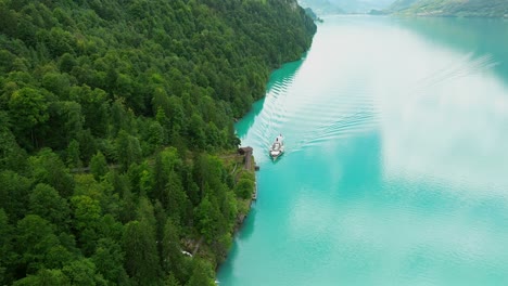 Vista-Aérea-De-Un-Barco-Que-Se-Acerca-A-Geissbach-En-El-Lago-Brienz,-Suiza