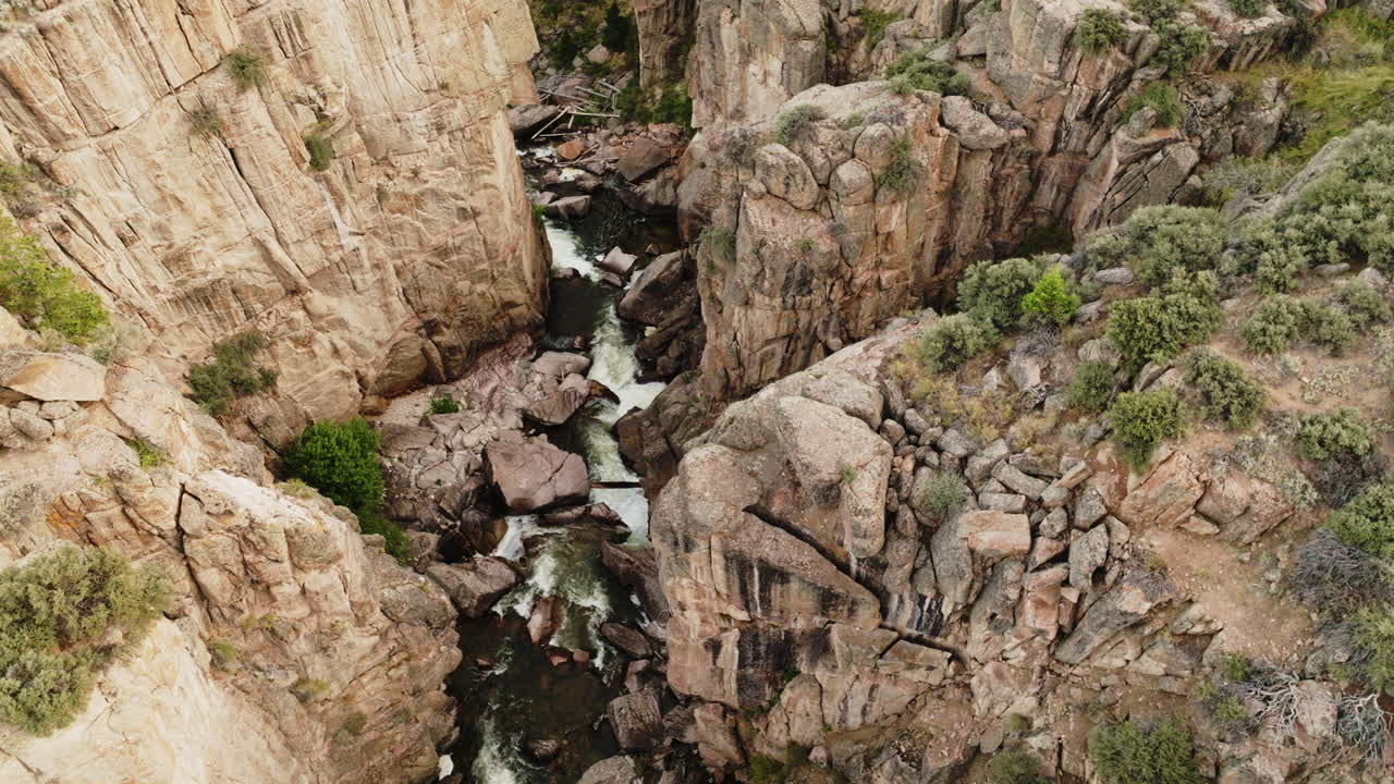 Bird’s-eye view of rock formations and a river meandering in a canyon.