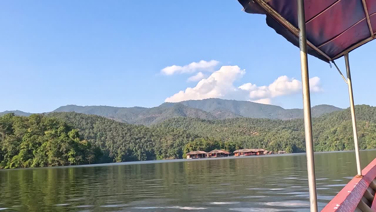 Enjoy a tranquil boat ride with stunning views of lush hills and a clear blue sky.