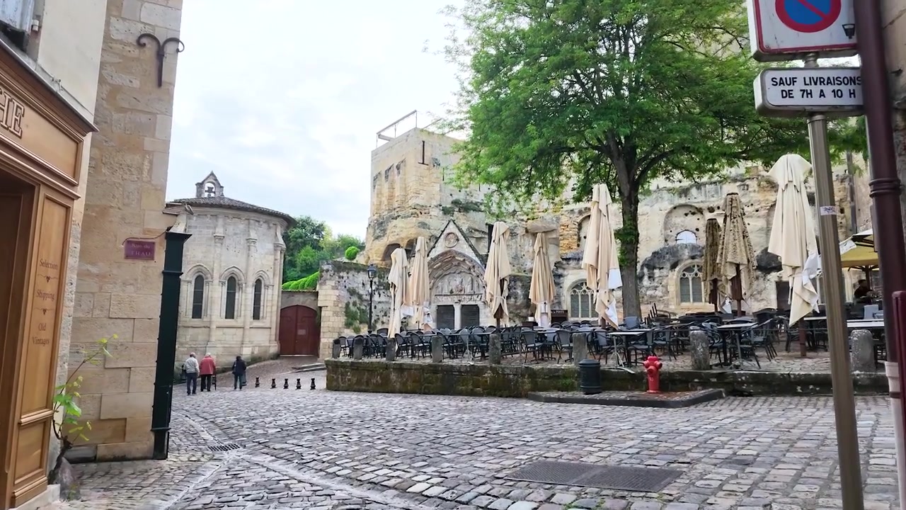 Een langzame voorwaartse camerabeweging door een historische geplaveide steeg richting een café