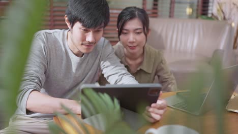 home finance,husband and wife discussing paper bill receipt from tablet laptop together on the floor at living room with focus and concentrate feeling with about family debt home interior background