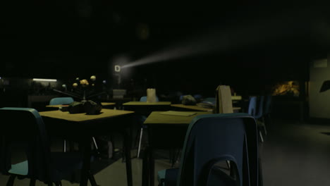 dimly lit classroom with projection equipment during an evening event