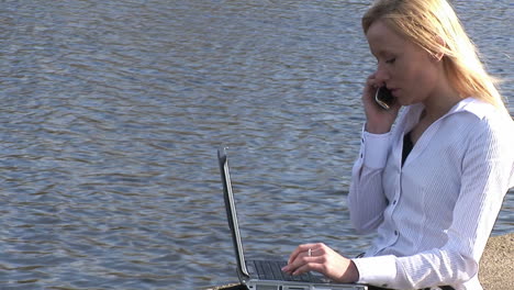 young attractive blonde woman on laptop outdoors