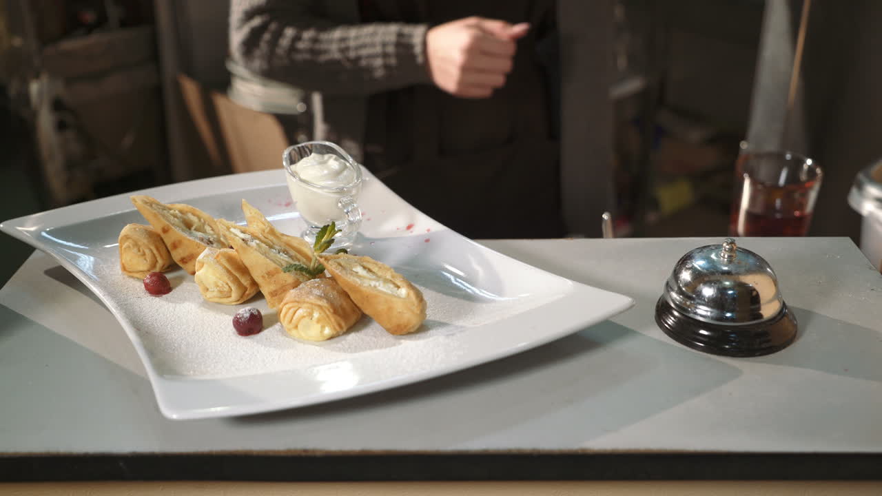 Waiter serving plate of dessert. Waiter in bringing the ordered dessert in restaurant