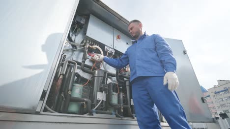 el técnico comprobando las líneas eléctricas del intercambiador de calor con pinzas de corriente