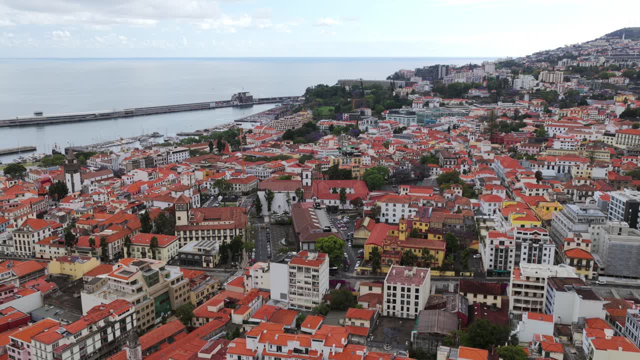 Panoramic view of Funchal, the capital of Madeira Island, Portugal, showcasing its characteristic red tiled roofs, the Atlantic Ocean, and the harbor