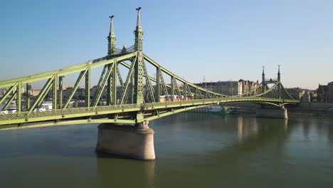 aerial boom shot reveals liberty bridge in budapest as train crosses bridge